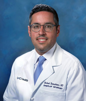 uci health urologist dr. michael daneshvar wearing a white coat in front of a blue studio background