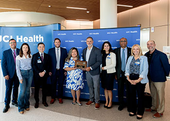 CEO Chad Lefteris is standing with UCI Health team members who were instrumental to the design and completion of the the hospital along with two Hensel Phelps managers.