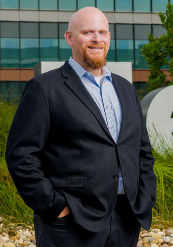 uci health director of facilities and general services joe brothman wearing a suit standing outside; photo credit goes to the irvine standard