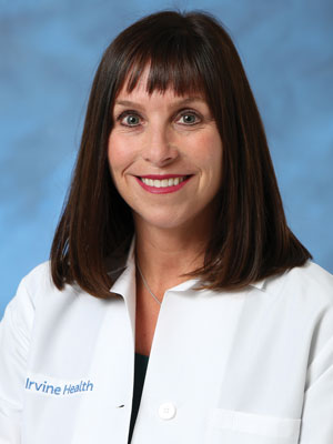uci health primary care physician dr. roxan engle in a white coat in front of a blue background