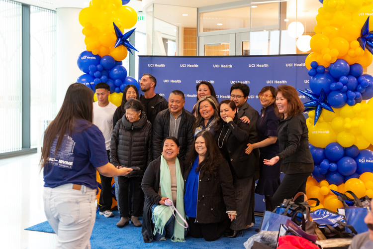 community members pose for a photo in front of blue and gold balloons and a blue step and repeat at the community unveiling of the uci health — irvine acute care hospital on saturday november 15