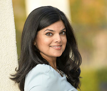 UCI Health rheumatologist Dr. Sheetal Desai wearing a white top smiles for the camera.