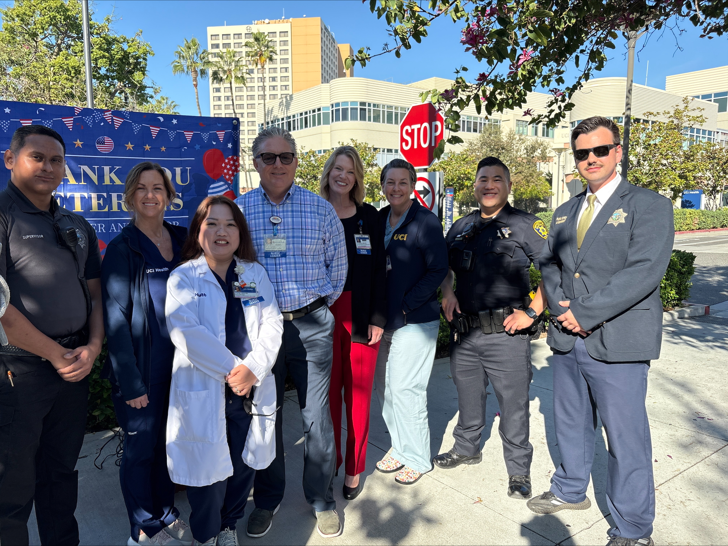 uci health leaders pose for a photo during a flag-raising ceremony to honor veterans who work at the academic health system and continue their service in the form of patient care