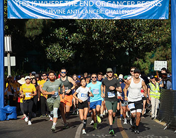 Throngs of  participants break into a run at the starting line for the 2025 UC Irvine Anti-Cancer Challenge  on the university campus in Irvine. 