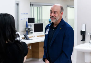 uci health president and ceo chad t lefteris in an area of uci health irvine, the new acute care hospital, smiles as he speaks to a co-worker