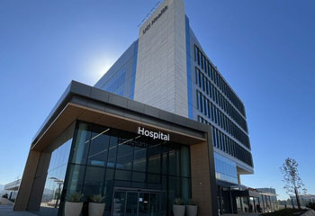 exterior of the uci health irvine acute care hospital in front of a blue sky