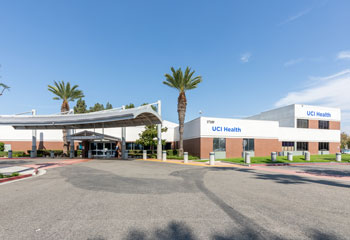 exterior of uci health fountain valley on a clear day with palm trees