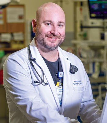 uci health irvine emergency medicine physician dr ryan gibney standing in an operating room wearing a white coat