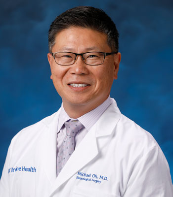 uci health physician dr. michael oh wearing a white coat in front of a blue studio background