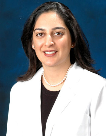 uci health geriatrician dr sonia sehgal wearing a white coat in front of a blue studio background