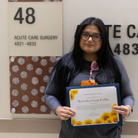 barenka cano a senior hospital assistant at uci health holds her sunflower award certificate