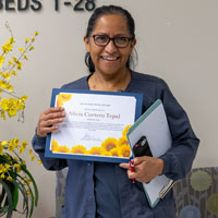 alicia cortero a senior hospital assistant at uci health holds her sunflower award certificate