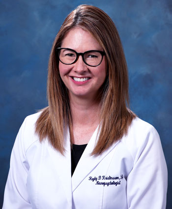 uci health neuropsychologist hayley kristinsson wearing a white coat and sitting in front of a blue studio background