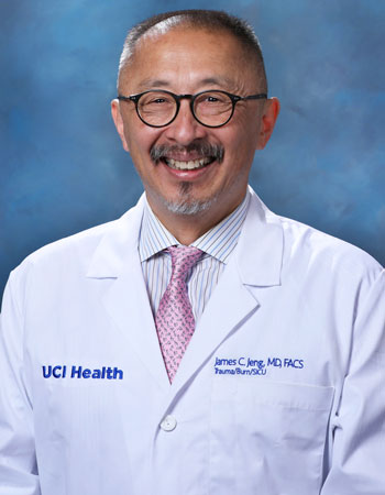 uci health burn trauma and critical care surgeon dr james jeng wearing a white coat in front of a blue studio background