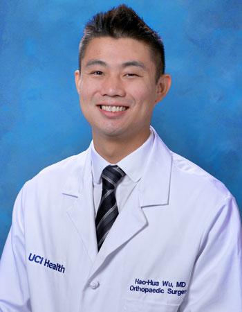 uci health orthopedic/orthopaedic surgeon dr hao hua wu wearing a white coat in front of a blue studio background