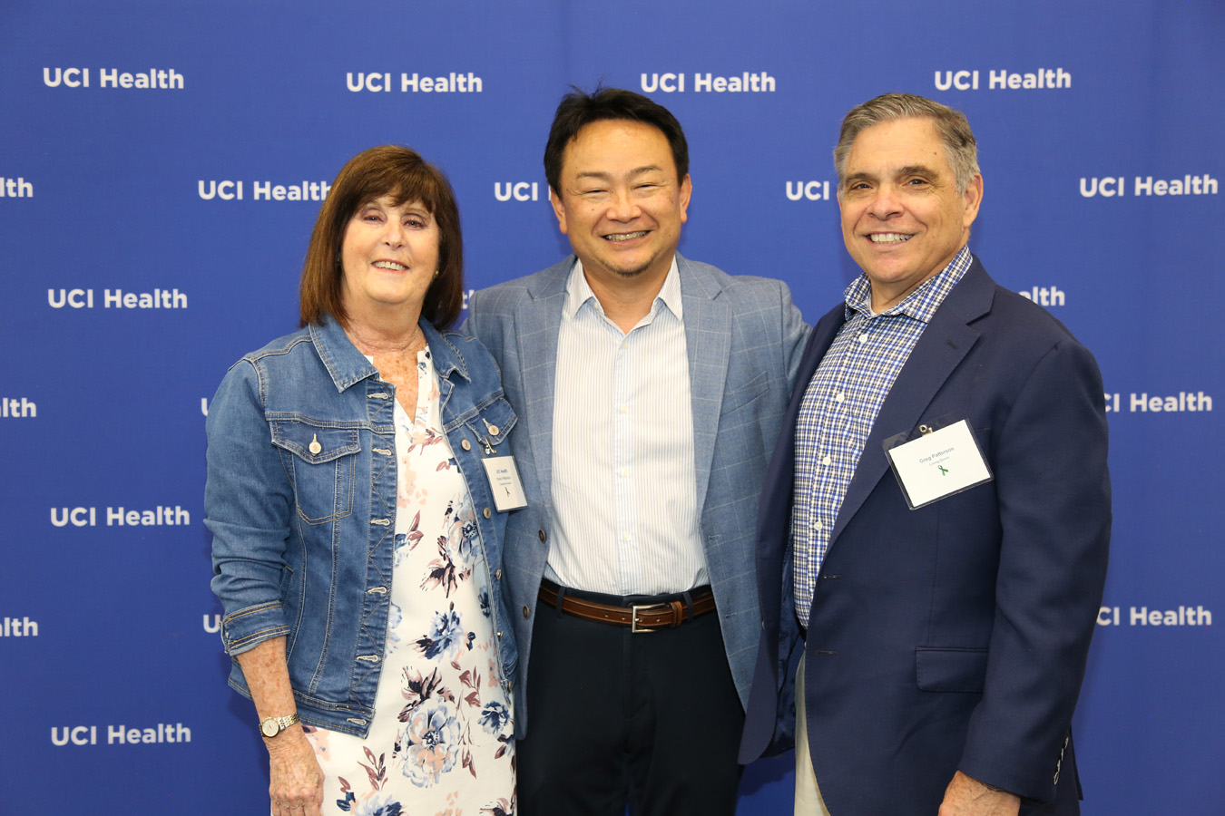 uci health kidney transplant recipients, donors and program co-workers celebrate at a special honorary event in April in front of a blue uci health step and repeat