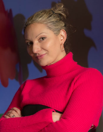 Natasha Mesinkovska,MD PhD Vice Chair, Clinical Research  standing with her arms crossed in a laboratory Photo: Steve Zylius/UCI