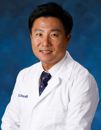 uci health dr. kyoungbin im in a white coat in front of a blue studio background