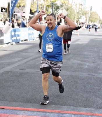 uci health kidney transplant recipient mark maselli raises his hands as he crosses the finish line at the las vegas marathon one year after his kidney transplant
