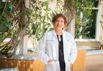 uci health geriatric neurologist dr claudia kawas stands outside wearing a white coat with her hands in her pockets