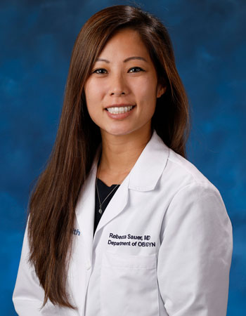 uci health dr. rebecca sauer in a white coat in front of a blue studio background