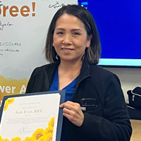 uci health respiratory therapist anh tran holds her sunflower award certificate