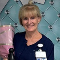 uci health nurse cheryl shaylor holds a bouquet of flowers as she celebrates earning the daisy award for nursing excellence