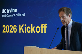 Dr. Richard Van Etten, director of the Chao Family Comprehensive Cancer Center, stands at a podium to announce grants awarded from the 2025 Anti-Cancer Challenge.