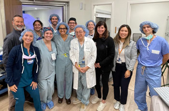 the huntington's disease clinical trial team gather for a photo in their scrubs after successfully treating their first patient for the condition