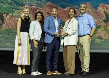 uci health co-workers accept an award for sustainability from healthtrust university on stage during the event ceremony