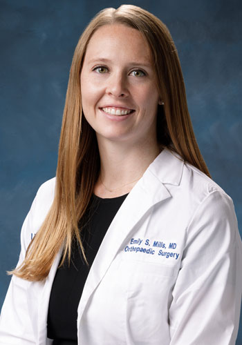 uci health orthopedic surgeon dr. emily mills wearing a white coat in front of a blue studio background