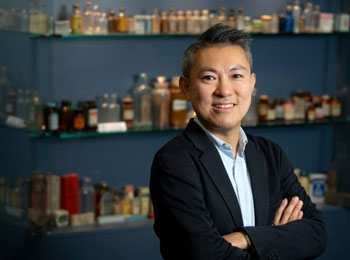 Alexandre Chan, UC Irvine professor of clinical pharmacy, stands in front of rows of bottles