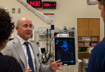 uci health emergency medicine physician dr christopher fox with one of the point of care ultrasound units at uci health