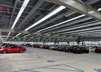 cars parked in the parking garage at uci health irvine with solar panels making up the ceiling