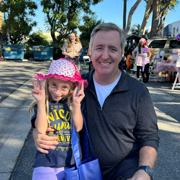 andrew donadee poses for a photo with his daughter blake at the NICU reunion carnival outdoors at UCI Health — Orange