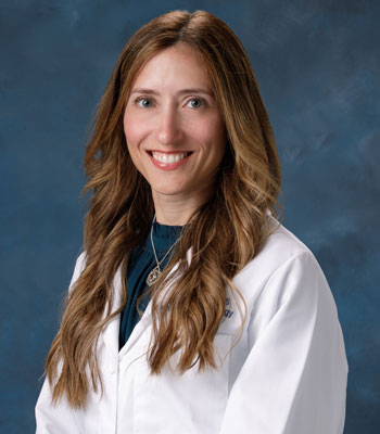 uci health surgical oncologist and breast cancer surgeon Dr. Alexandra Lopez-Aguiar wearing a white coat in front of a blue studio background