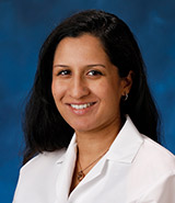 Dr. Anjani Kolahi, pictured in her lab coat, is a board-certified UCI Health family medicine physician who specializes in primary care and hospital medicine.