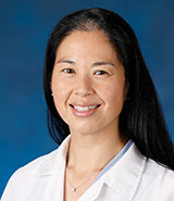Dr. Isabella Kuo, pictured in her lab coat, is a board-certified UCI Health surgeon who specializes in vascular and endovascular surgery. 
