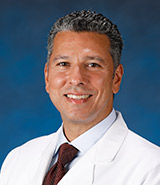 Dr. Ahmed Mohyeldin, pictured in his lab coat, is a UCI Health neurosurgeon who specializes in skull base and endoscopic cranial surgery. pituitary surgery, brain tumors and neuro-oncology.