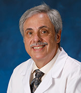 Dr. Alan Schenk, pictured in his white lab coat, is a board-certified UCI Health rheumatologist, who specializes in osteoporosis, musculoskeletal ultrasound and clinical bone densitometry..