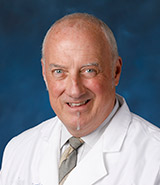 Dr. David Swope, pictured in his lab coat, is a board-certified UCI Health neurologist who specializes in the treatment of movement disorders, including Parkinson's disease. 