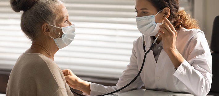 doctor uses stethoscope to listen to senior women's heart