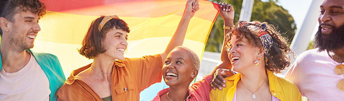 Happy LGBTQ+ group with rainbow flag.