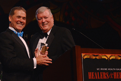 UCI Health CEO Terry Belmont presents the leadership award to philanthropist Michael Hayde at the 2014 UCI Health gala, Healers & Heroes.