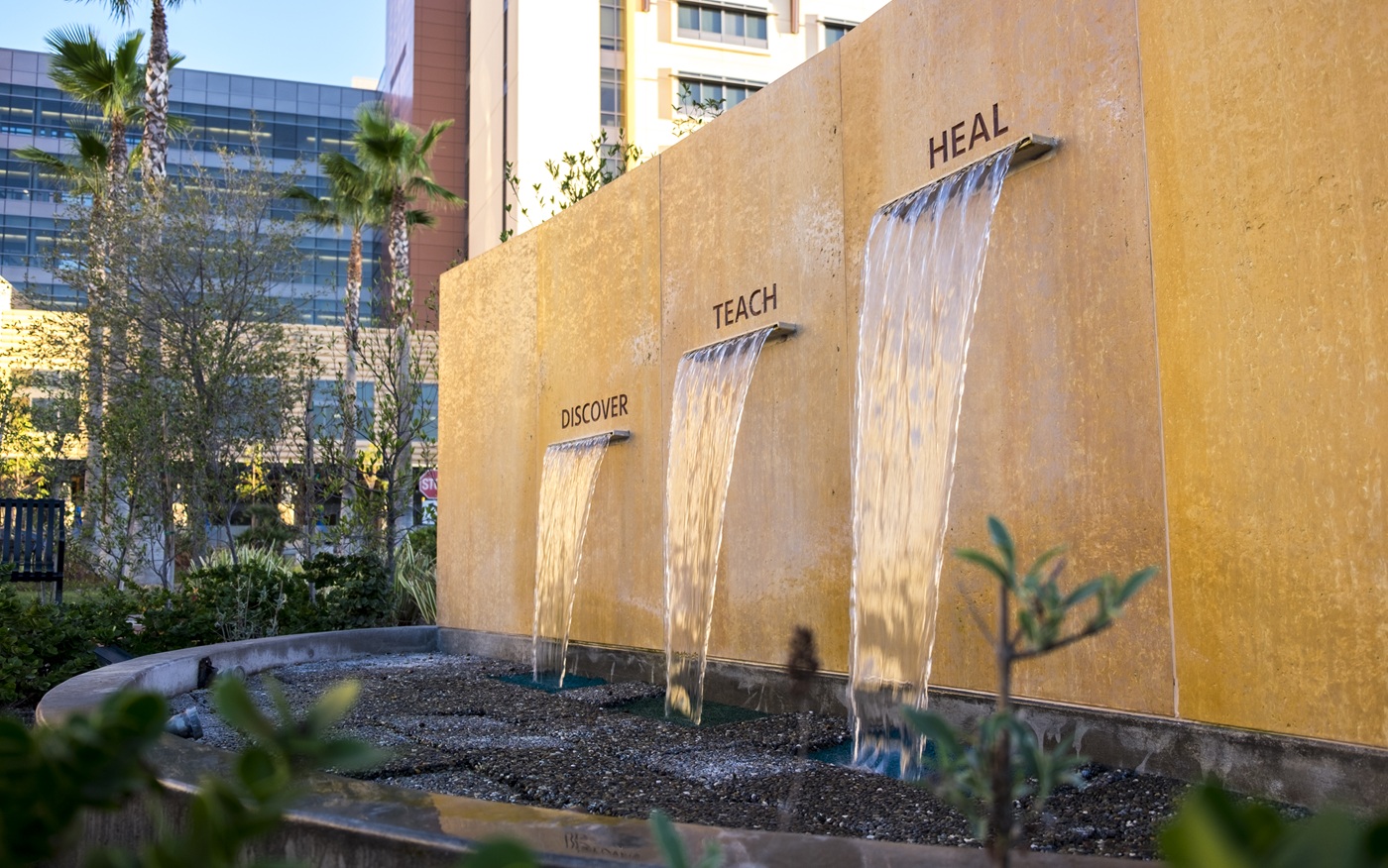 The fountain at UCI Medical Center in Orange that denotes "Discover. Teach. Heal."