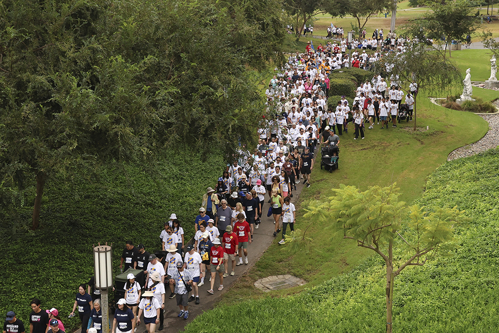 an overhead image of a large crowd of walkers on a path during the anti-cancer challenge at uc irvine