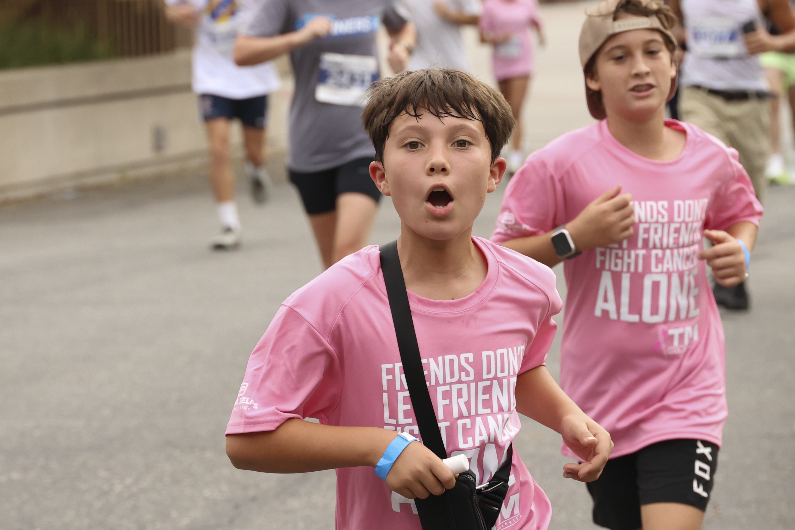 two young children in pink t-shirts run during the 2026 uc irvine anti-cancer challenge 