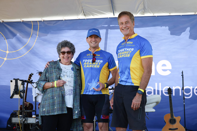 participants in the 2025 uc irvine anti-cancer challenge stand on stage, including the challenge founder oncologist dr. richard van etten and oncologist dr. lauren pinter-brown