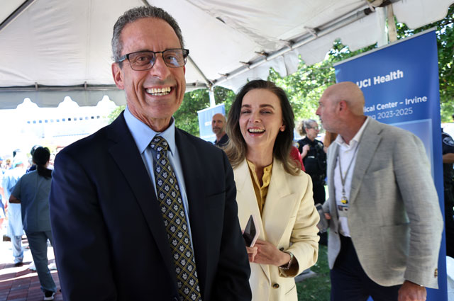 uci health school of medicine dean dr. michael stamos and chief strategy officer tatyana popkova celebrate at a beam signing ceremony for uci health irvine