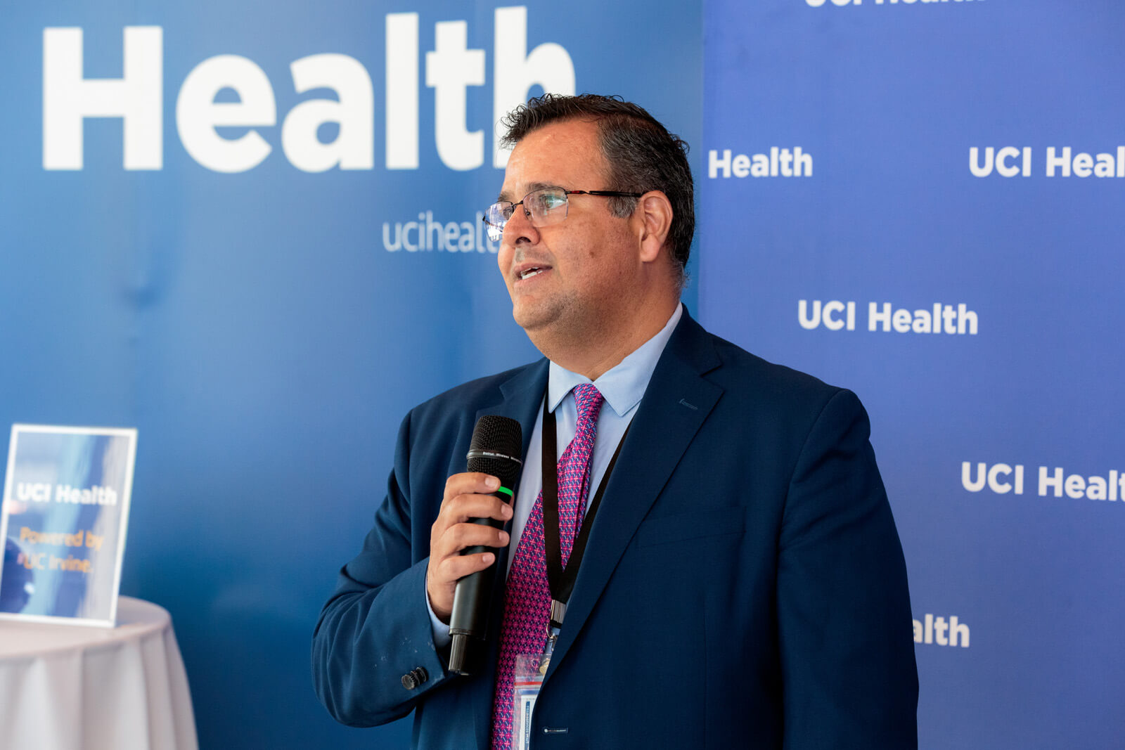 a leader from hensel phelps speaks in front of a uci health step and repeat at the uci health irvine substantial completion event on sept 19 2025